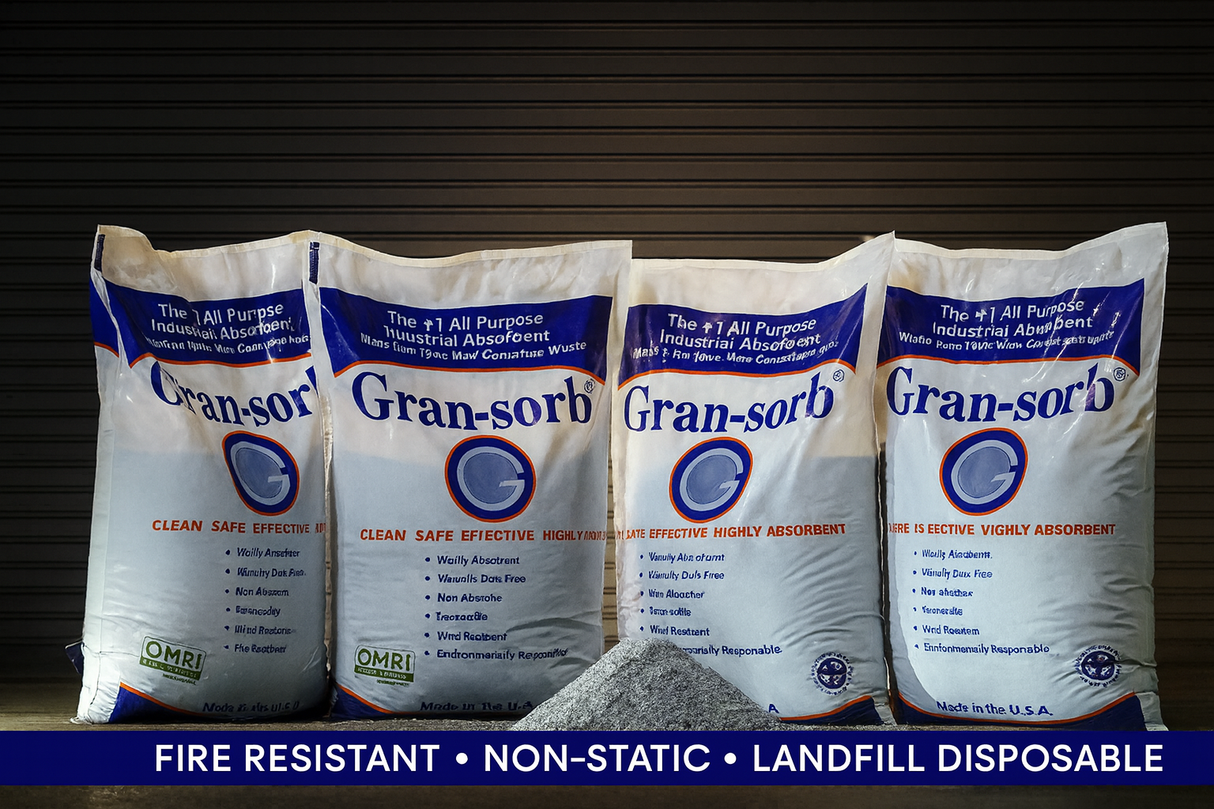 Bags of granular absorbent lined up with a pile of material in front of the bags against a dark background and a text ribbon that reads fire resistant, non-static, landfill disposable.