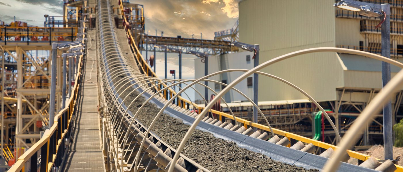 Industrial conveyor belt transporting materials in a factory setting.