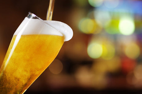 View of a amber yellow beer in a mug with frothy foam