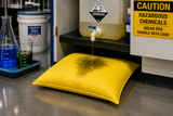 Yellow Hazmat absorbent pillow capturing a chemical leak in an industrial laboratory setting