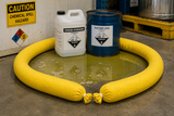 Yellow hazmat absorbent sock containing a chemical spill around industrial equipment